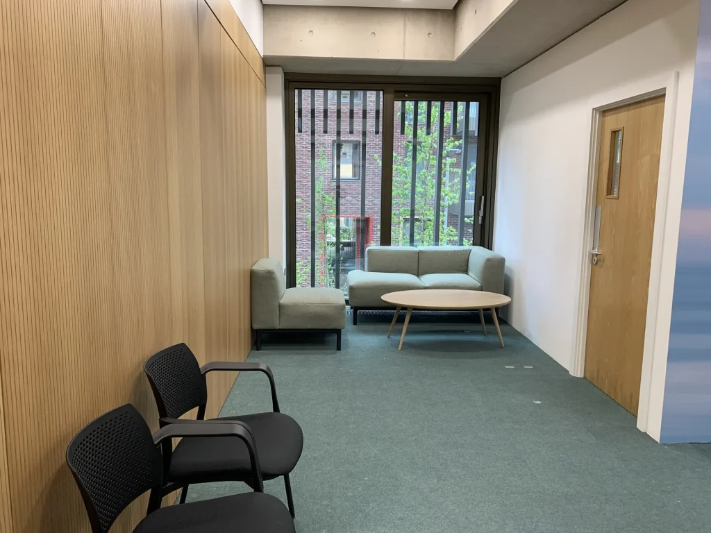 Small meeting nook at Eckstein Road S.W. with sofa, armchair and round coffee table