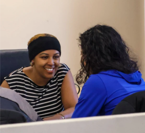 Two learners smiling and talking together during a session